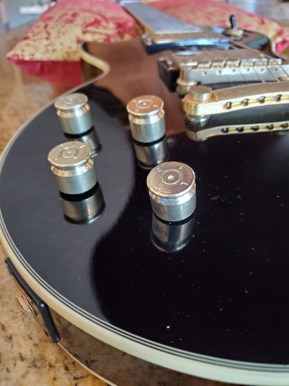 Guitar knob made with recycled 50 caliber casing on black electric guitar