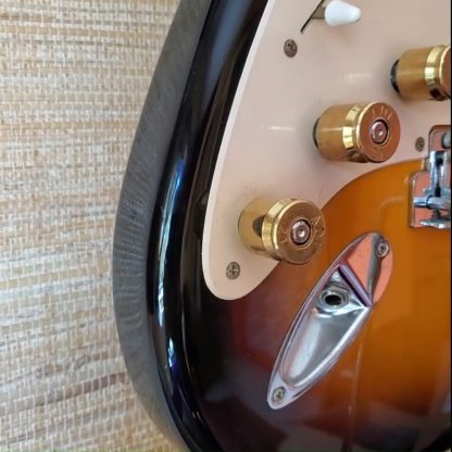 Three guitar knobs made with recycled 50 caliber casing on electric guitar